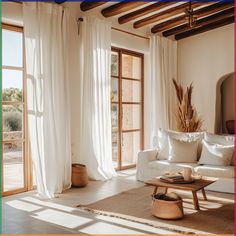 a living room filled with furniture and lots of white drapes on the windowsill