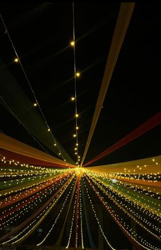 the ceiling is decorated with lights and streamers in an indoor space that looks like it has been lit up at night