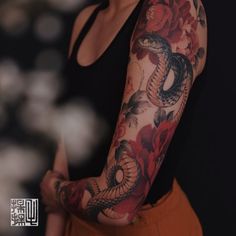 a woman with a snake tattoo on her arm