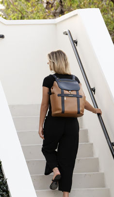 a woman is walking up some stairs with a backpack