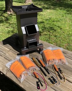 an outdoor grill with five different types of cooking utensils on it, sitting on a picnic table