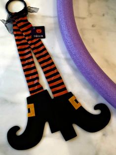 an orange and black striped sock with a ring on it next to a purple tube