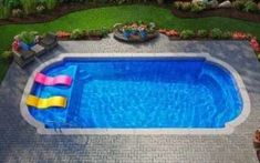 an aerial view of a swimming pool with a slide in the middle and lawn furniture around it