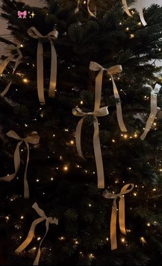 the christmas tree is decorated with lights and ribbons