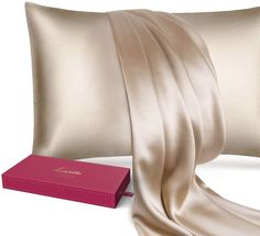 a satin pillow with a pink box next to it