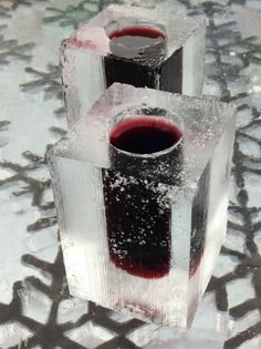 three ice cubes with red liquid in them sitting on top of snow covered ground