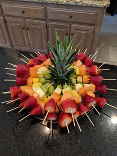 a fruit platter with pineapples, strawberries, and bananas arranged in a circle