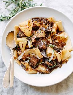 a white bowl filled with pasta and meat