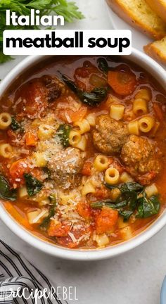 italian meatball soup in a white bowl with bread on the side