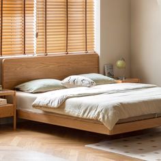 a bed sitting in a bedroom next to a window with blinds on the windowsill