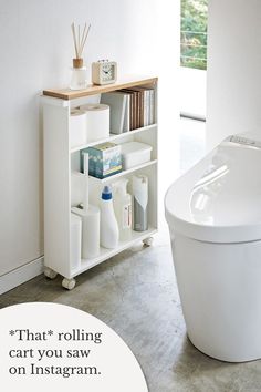 White rolling storage cart holding cleaning products, toilet paper, hygiene items, books, and decor in the bathroom by Yamazaki Home. Bathroom Cart, Rolling Storage Cart, Rolling Storage, Storage Cart, Bathroom Items, Minimalist Bathroom, Storage Hacks, Bathroom Essentials, Bathroom Organization