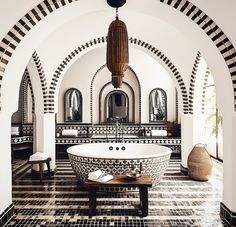 a bathtub in the middle of a room with black and white tiles