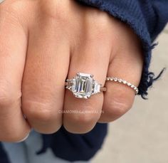 a close up of a person's hand with a ring on it and a baguette in the middle