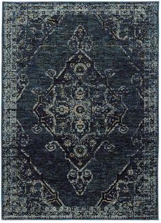 a blue rug with an ornate design on the front and back side, in grey tones