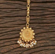 Indian Bridal Traditional One Gram Jewelry Tikka Height = 155 mm || Width = 32 mm Plain Gold Tikka Antique Maang Tikka Gorgeous 24 K gold plated. Whether you are the bride or sassy bridesmaid, no lehenga is complete without a maang tikka. This Kundan pearl maang tikka is perfect to steal the show with its elegance . The meticulous attention paid to the craftsmanship makes it an epitome of jewelry inspiration. 100% Satisfaction Guarantee: Long Lasting Plating, High-Quality Stones. Gifting: This p Kundan Temple Jewelry Tikka For Rituals, Round Temple Jewelry Tikka For Festive Occasions, Temple Jewelry Style Tikka As Gift, Festival Puja Tikka With Intricate Design, Festive Puja Tikka With Intricate Design, Festivals Puja Tikka With Intricate Design, Festive Round Tikka Temple Jewelry, Temple Jewelry Round Tikka With Cutdana, Temple Jewelry Chandbali Tikka For Rituals