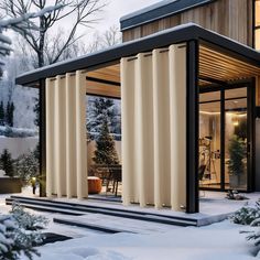 a modern house with sliding doors in the front yard and snow on the ground outside