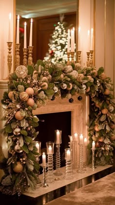 a mantel decorated with candles and greenery in front of a fire place filled with christmas decorations