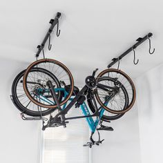 two bikes are hanging from the ceiling in a room