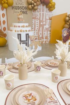 the table is set with plates, cups and vases on it for a children's birthday party