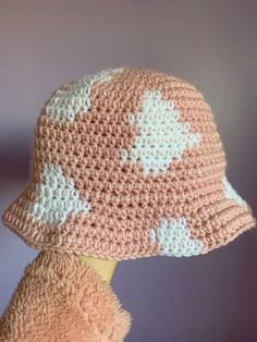 a crocheted pink and white hat sitting on top of a stuffed animal's head