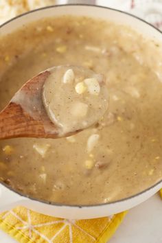 a wooden spoon in a pot filled with soup