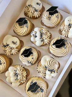 cupcakes with white frosting and black icing decorated with graduation caps on them