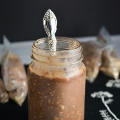 a jar filled with food sitting on top of a black table next to other items