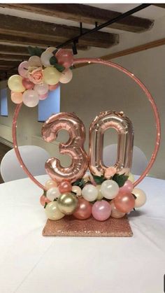 the number 30 is surrounded by balloons and flowers on top of a round cake plate