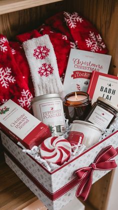 a christmas gift basket filled with candles, books and other holiday gifts for someone special