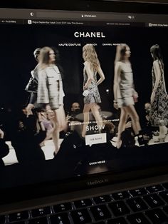 a laptop computer displaying a fashion show on the screen