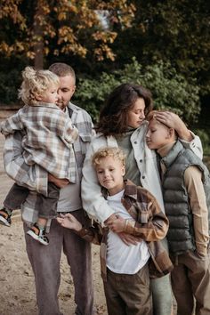 a group of people standing next to each other on a dirt ground with trees in the background