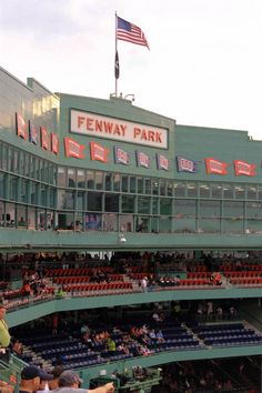 an empty fenway park baseball stadium with fans in the bleachers and onlookers