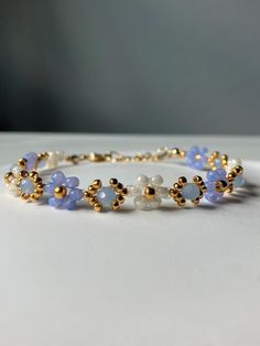 a bracelet with blue and white beads on top of a table next to a wall