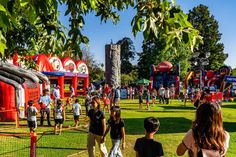 people are standing in the grass at an amusement park