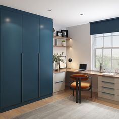 a room with blue cabinets and a desk in the corner next to a large window