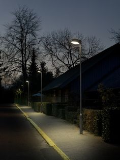 an empty street at night with no one on it and some trees in the background