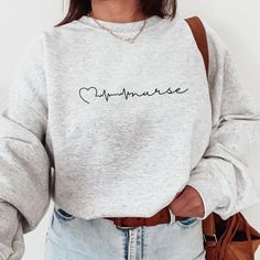 a woman wearing a grey sweatshirt with the word cupcake printed on it in cursive writing