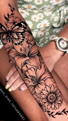 a woman's arm with flowers and butterflies on it