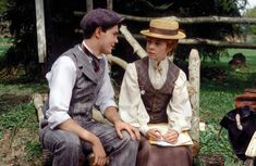 two people sitting on a bench talking to each other