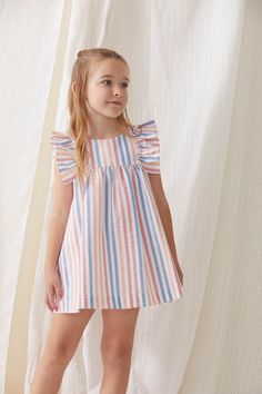 Brand: Tartaleta Reference: B4631.B463 Color: Multicolor Composition: 100% cotton Description: ﻿This dress is made in a striped, orange, coral and blue fabric. It has ruffles on the sleeves and fastens with buttons in the back. Intended Age: Toddler Girl, Girl Size Guide: ﻿This brand runs small. Please size up. Summer Outfits For Kids, Spoiled Girl, Kids Dress Clothes, Toddler Girl Dresses Summer, Cotton Frocks For Kids, Kid Dress, Kids Summer Dresses, Fancy Short Dresses, Informal Dress