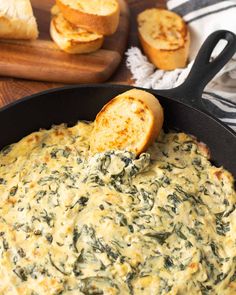 spinach dip in a skillet with bread on the side