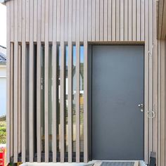 the front door of a house with wooden slats on the side and an entrance