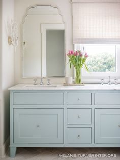 a bathroom with two sinks and a large mirror over it's double vanity area