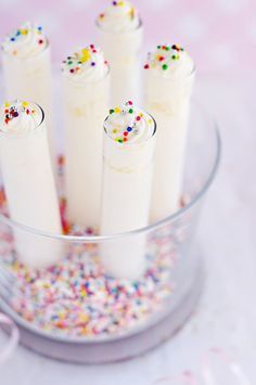 a glass bowl filled with cake batter and sprinkles on top of a table