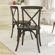 two black chairs sitting on top of a white rug in front of a dining room table