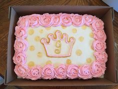 a birthday cake in a box with pink frosting and gold decorations on the edges