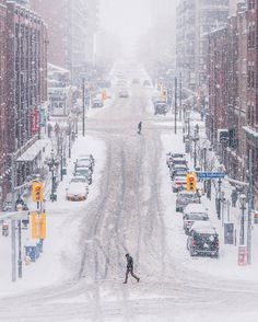 a person walking across a snow covered street