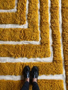 a person standing on top of a yellow rug