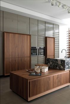 a modern kitchen with wooden cabinets and marble counter tops, along with stainless steel appliances