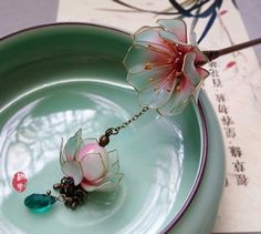 two glass flowers on a green plate with chinese writing in the backgrounnd